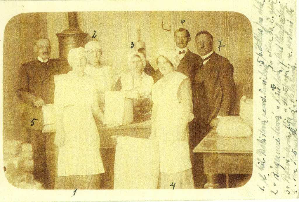 04_029.jpg - Rozvažování a prodej mouky na radnici ve válečné době let 1914 – 1915, před vydáváním chlebových výkazních lístků. 1.sl.Pavlištová, 2.sl.Burgermeistrová, 3.sl.Jířa Barvínková, 4.sl.Ros. Krčmaříková - Kalábová, 5. obchodník Jan Faltus, 6. ředitel spořitelny František Theer, 7. vedoucí poštovního úřadu Antonín Charfreitag