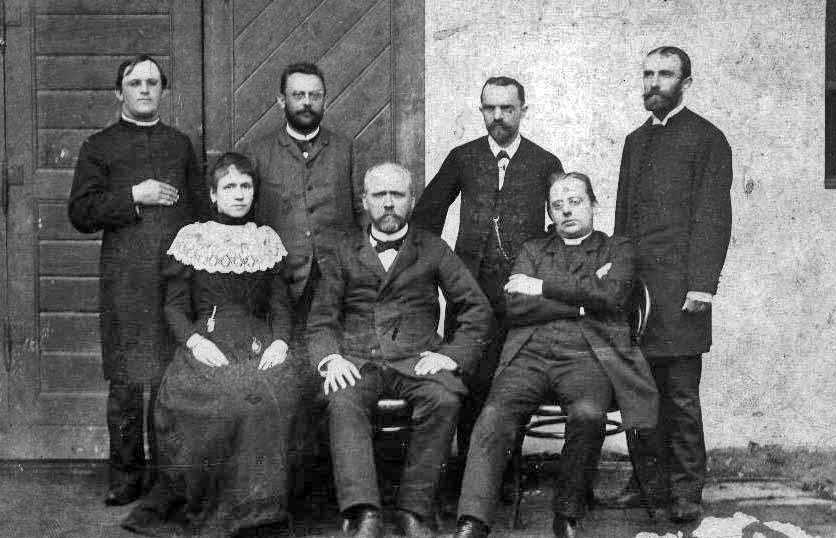 18_005.jpg - Učitelský sbor kolem roku 1895, vzadu zleva: katecheta Radouš, Bedřich Šmoranc, Antonín Krčmařík, František Dostál; vpředu zleva: Eliška Zvěřinová, Josef Kadleček katecheta Šklíba