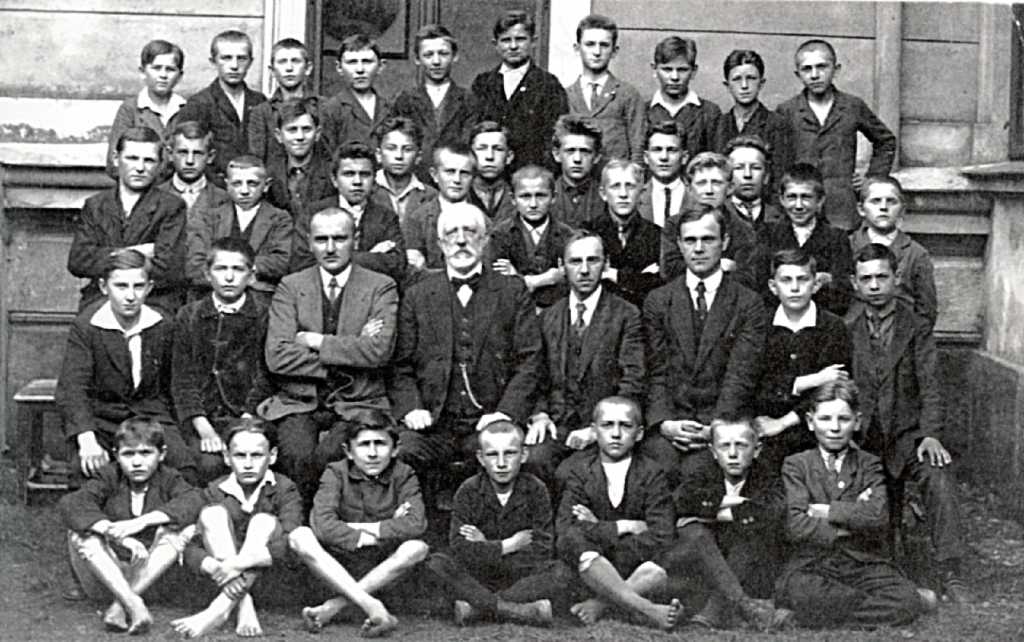 18_007.jpg - Ředitel Václav Kotek, vpravo od něho Rudolf Vaníček, v první řadě sedící, druhý zleva je budoucí diplomat Josef Korbel, kolem roku 1920