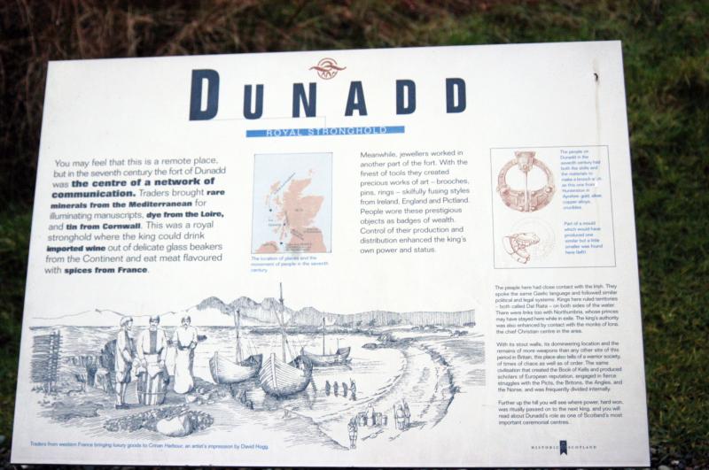 NIK_D100_4562.jpg - Dunadd..Dle pověsti v malém království na území zeleného ostrova (dnešní irská provincie Ulster) žil hoch jménem Fergus Mór mac Eirc, jenž byl krom jiného též příslušníkem místní panovnické dynastie. Jednoho dne (kolem roku 500 n. l.) společně se svými bratry usedl do člunu, přeplaval moře oddělující Irsko od Skotska a na jihozápadě Skotska založil království Dalriada. Praotec rodu Ferguse Mór mac Eirca byl věhlasný keltský válečník, který se se svými spolubojovníky během válečných výprav dostal až do dalekého Egypta. Zde se válečník zamiloval do dcery faraona, která se jmenovala Scota (už Vám svítá).  Faraónova dcera se za něho provdala a odjela s ním do vzdáleného Irska, kde se stala pramátí vládnoucího rodu malého království. Přivezla s sebou i posvátný kámen, později známý jako kámen osudu (Stone of Destiny), na němž dle pověsti spal biblický Jákob v onu osudnou chvíli, kdy viděl stoupat anděly do nebe. Fergus, jako právoplatný dědic, si tento kámen s sebou samozřejmě přivezl do svého nového království a jeho obyvatele po své urozené pramáti nazval Skoty. Tolik legenda.Na této skále se nacházela pevnost Dunadd v Argyllu, hlavní město království DalriadaNa území dnešního Argyllu (samo jméno “Argyll” pochází z keltského Earra Ghaidheal - pobřeží Keltů) se irští Skoti usazovali již krátce po opuštění území Římany a vytvořili zde království Dalriada. Nutno připomenout, že společenský systém skotského království Dalriada kopíroval systém irský, který rozeznával tři královské hodnosti. Dle tohoto rozdělení stojí na vrcholu rí ruirech (král král, neboli král celé země), pod nímž jsou ještě dvě kategorie vůdců neboli králů: ruirí - vyšší král, který vládl několika rodům (královstvím) a rí - král, který vládl jednomu rodu (království). Skotská Dalriada byla již od počátku 6. století rozdělena do čtyř částí, které si rozdělily čtyři rody - ve staré irštin zvané cenéla - Loairn, nGabhráin, n Oengus, Comgaill, po nichž byla tato jednotlivá království i nazvána. Dokonce víme, jak byla tato území geograficky rozdělena. Rod nOengus ovládal území Islay; rod Loairn ovládal území Colonsay; rod Comgaill ovládal území dnešního Cowalu; rod nGabráin ovládal území Kintyre, Arran a Bute a současně jeho vládce byl i rí ruirech - panovníkem Skotů.